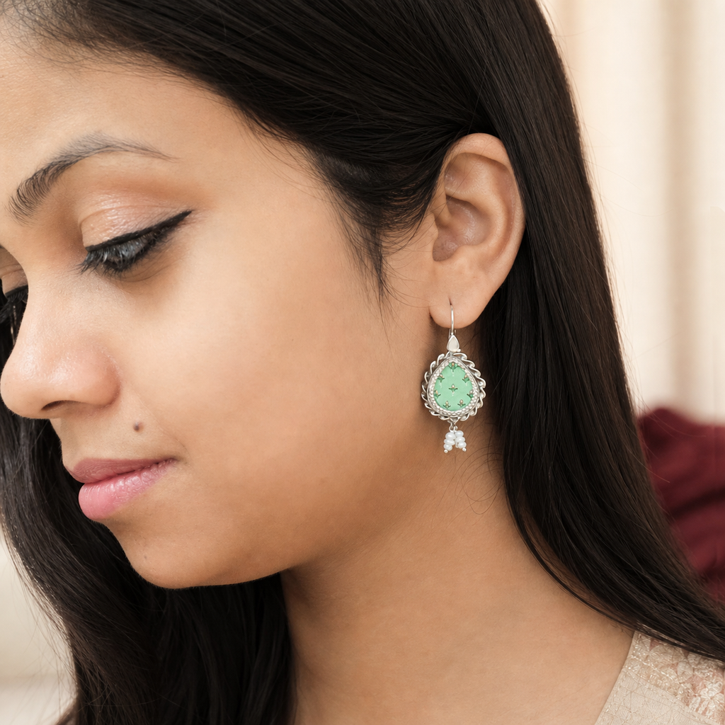 Green flower painted silver earring worn on the ear