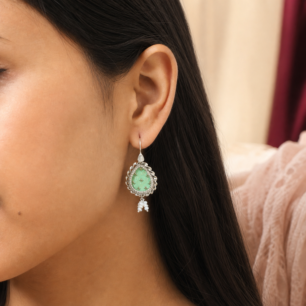 Green flower painted silver earring worn on the ear