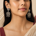 Oxidized silver floral dangler earrings worn on both ears