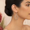Silver open teardrop fishhook earring worn on ear
