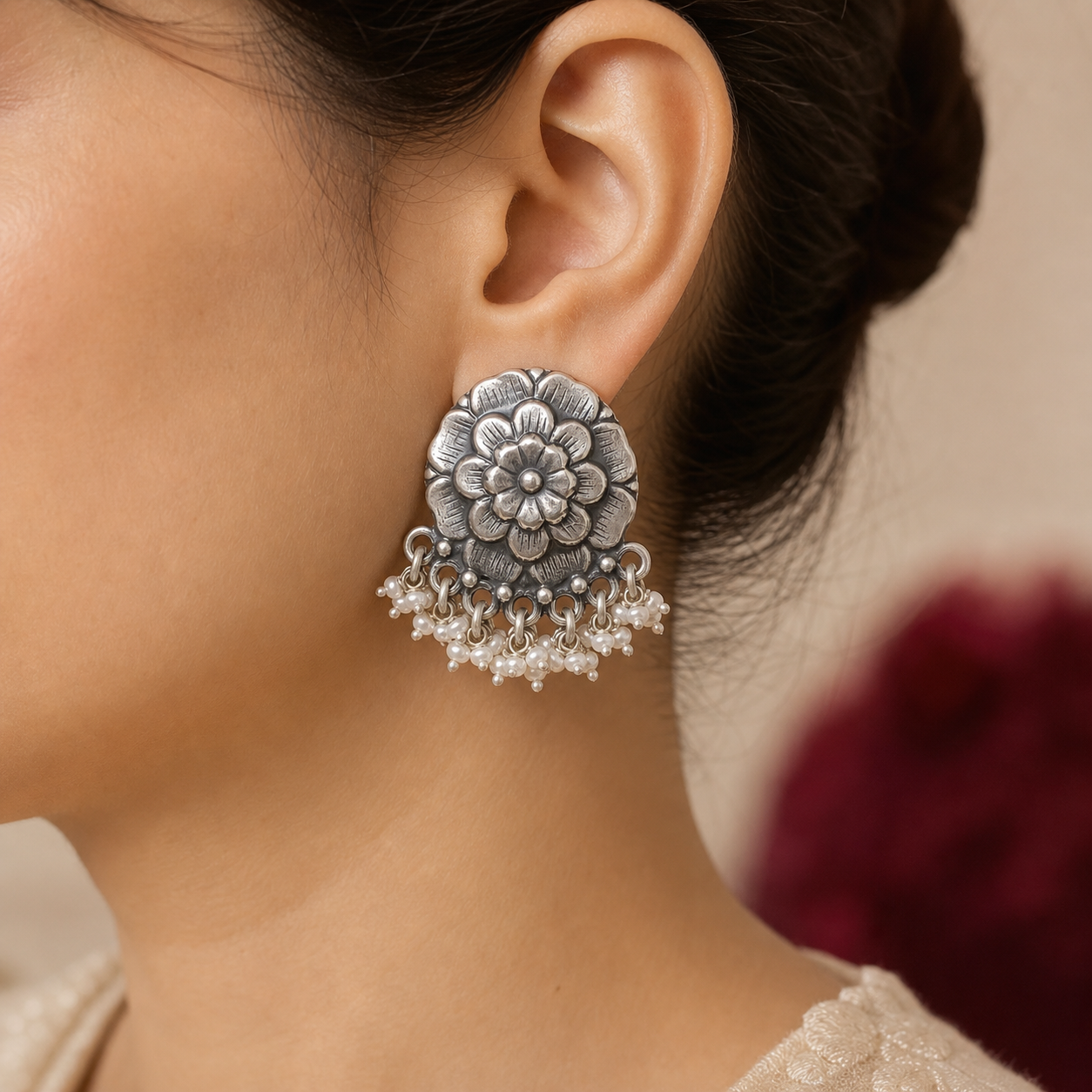 Oxidized silver flower pearl stud earring worn on the ear