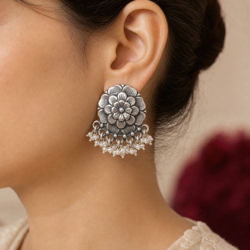 Oxidized silver flower pearl stud earring worn on the ear